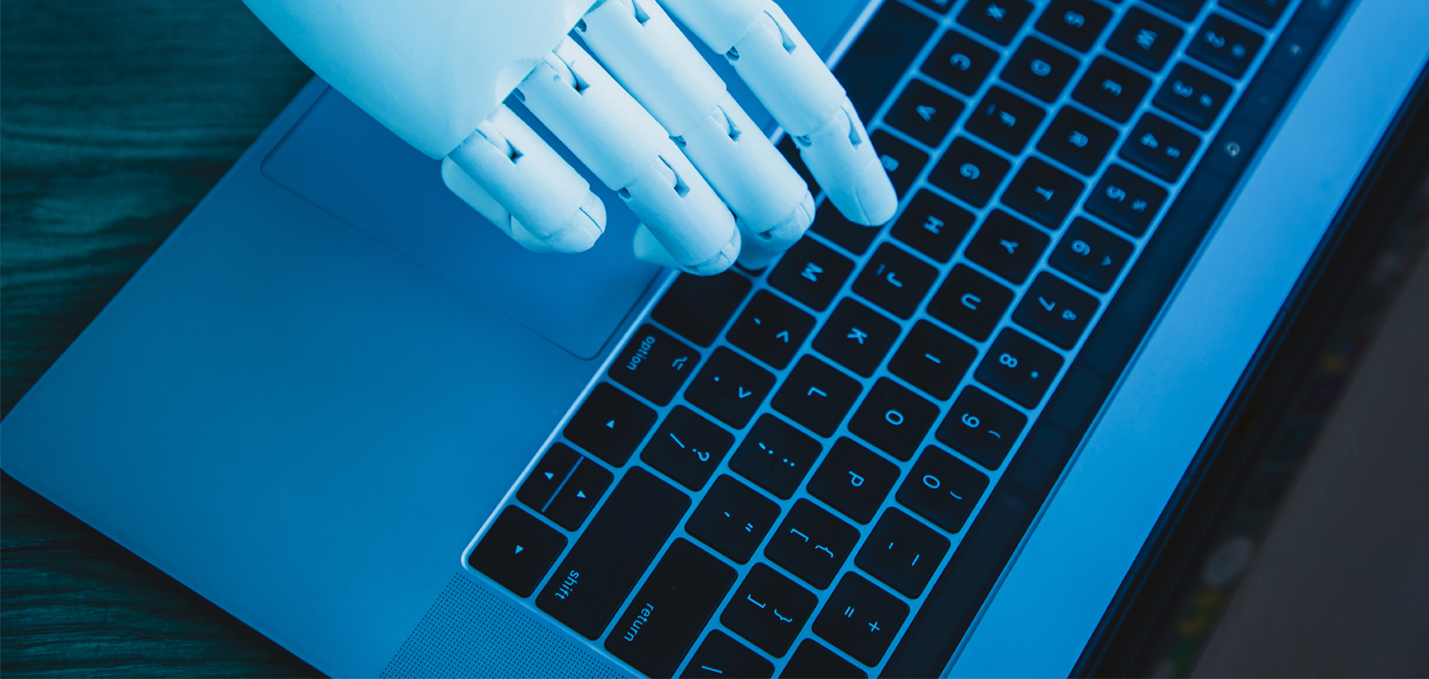 robotic hand using laptop (concept of AI replacing white collar worker)