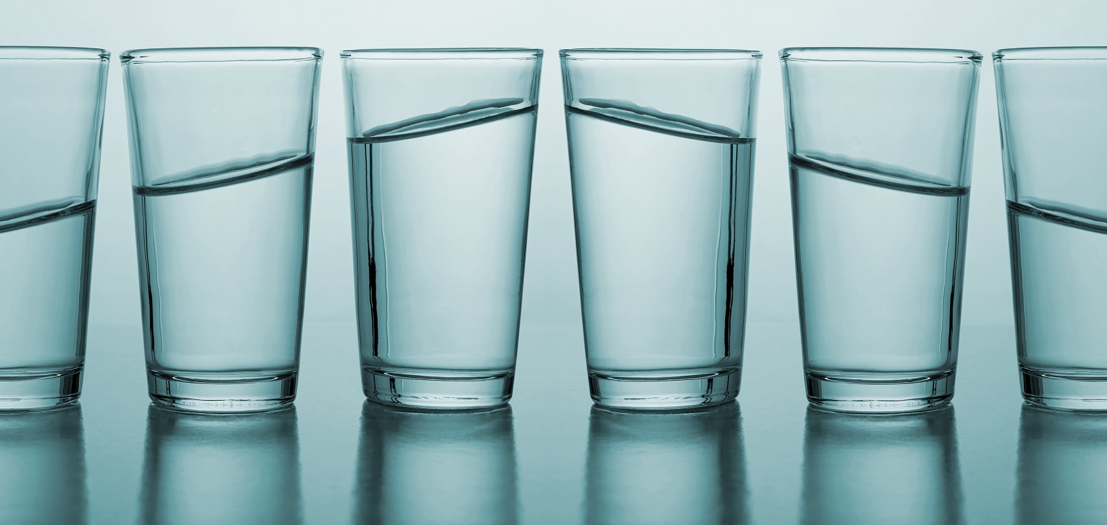 A row of glasses with varying amounts of water they grow from empty to full and descending from full to empty